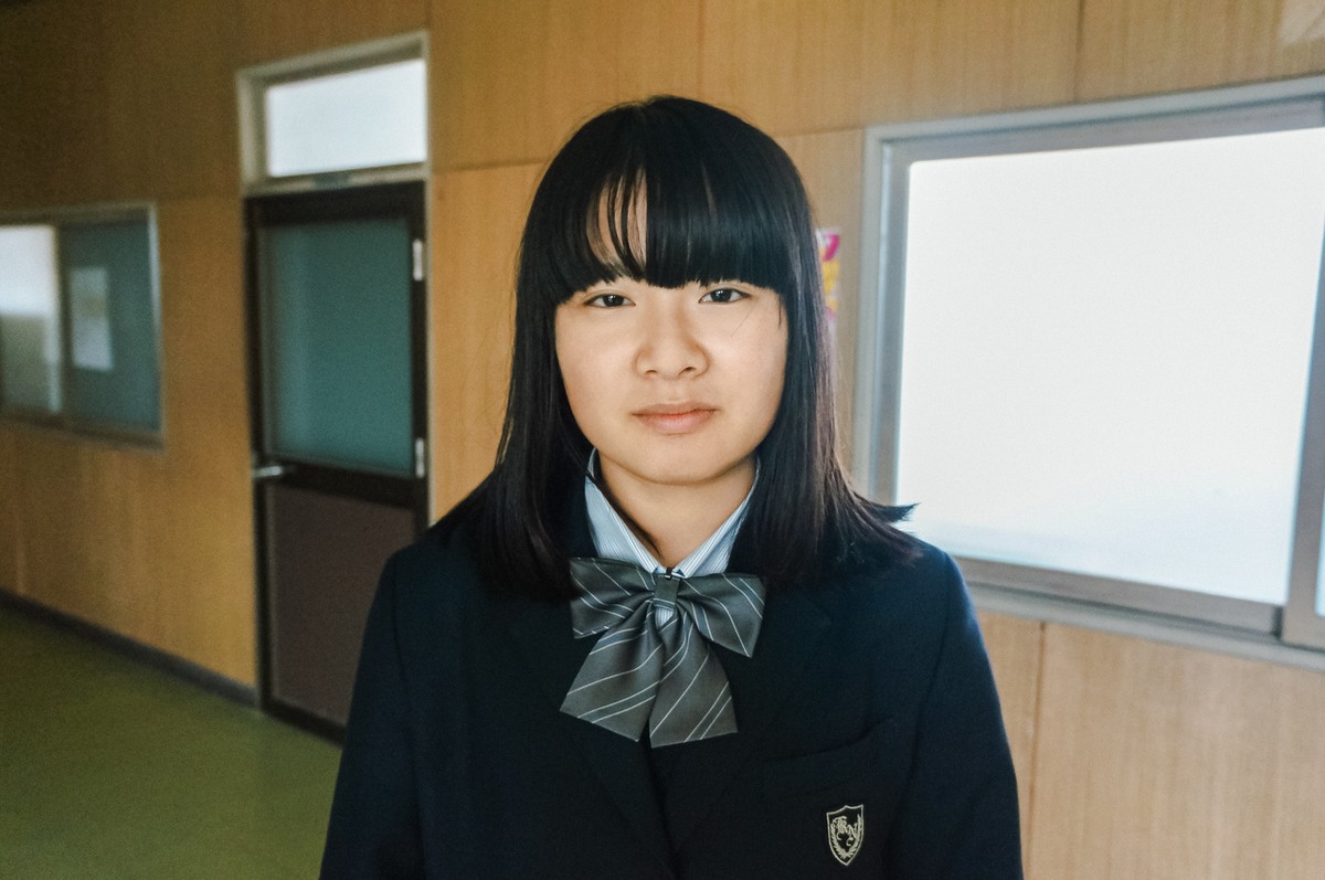放課後、教室でこちらを見つめる制服姿の彼女。