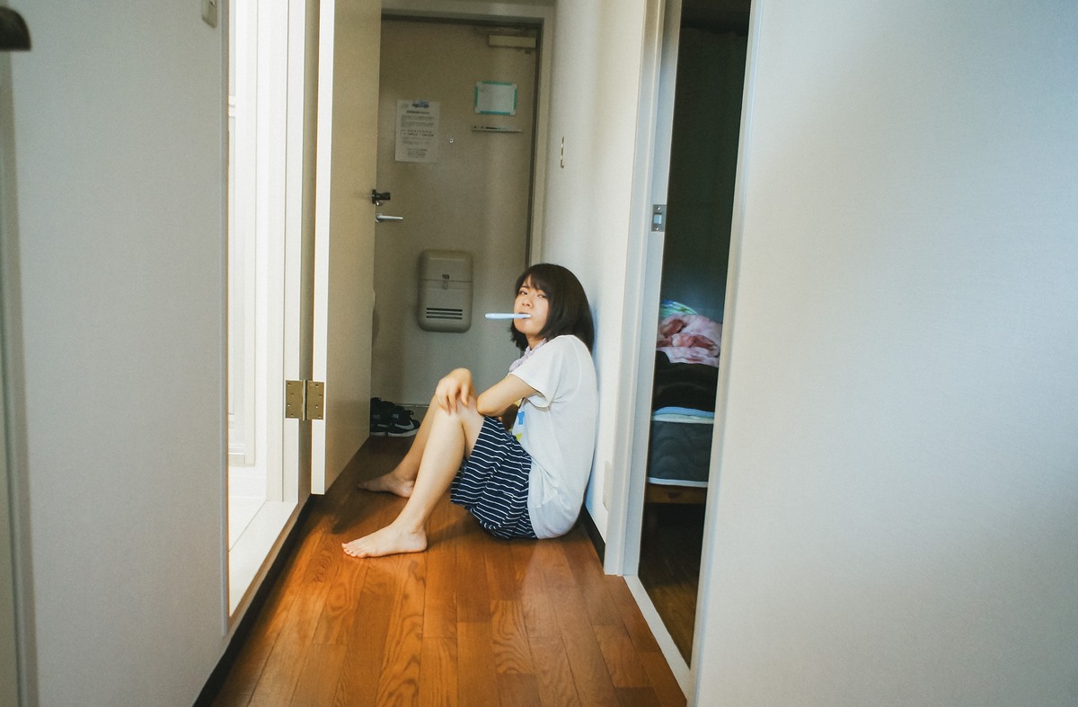 日差しの入る廊下で、床に座る彼女。